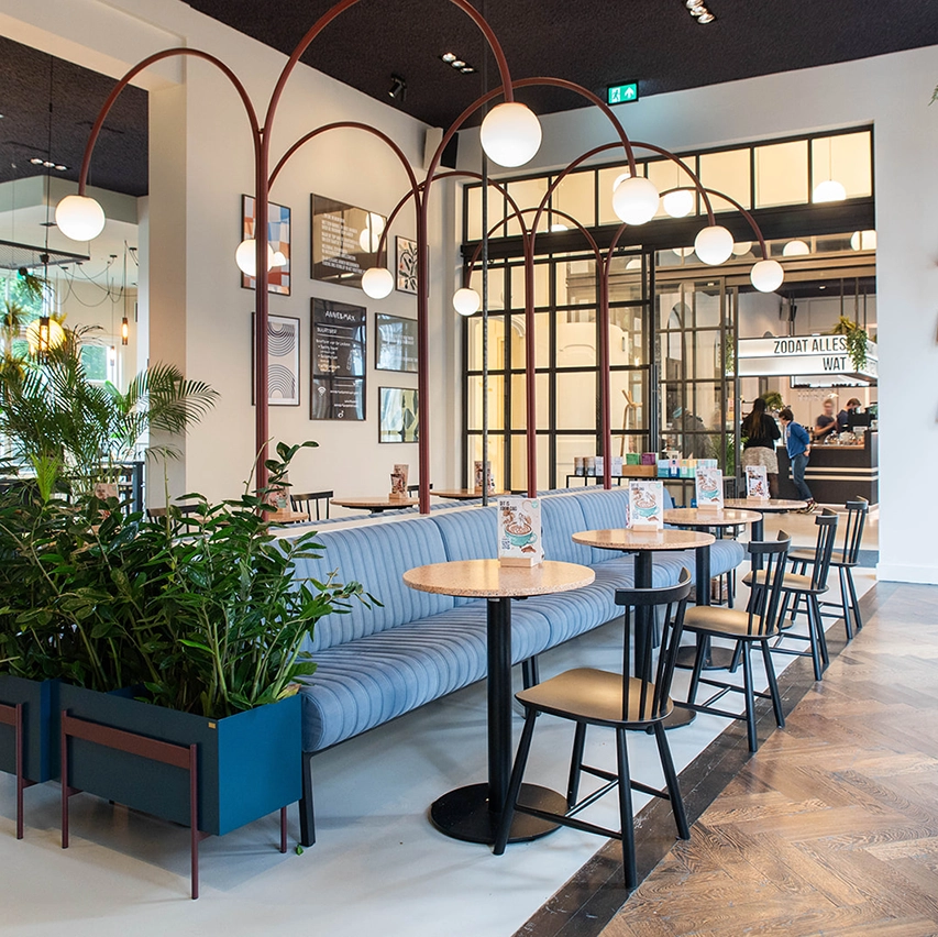 Restaurant interior at Anne&Max Boutique Hotel in Utrecht, featuring arching lamps between custom banquettes - design by Studio JAAF
